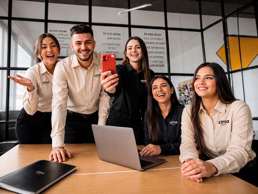 Equipo de Xima Group colaborando en un ambiente de trabajo profesional.